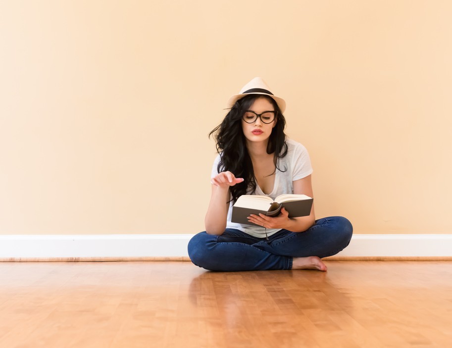 Young woman reading a book in a big room